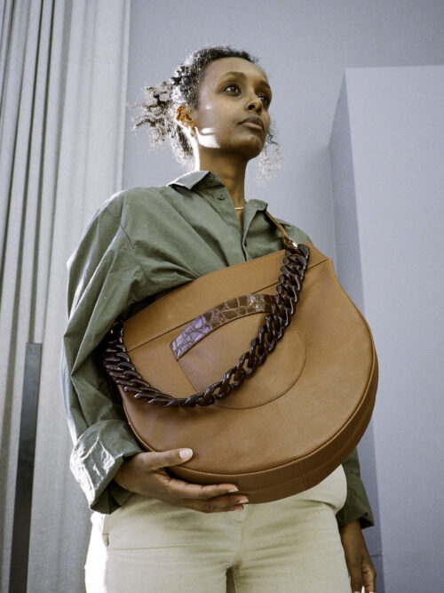 large besace bag revisited. Elegant, original style. tortoiseshell chain. unique design. half-moon that can be worn on the shoulder or across the chest. practical, decorative front pocket. holds a notebook and A4 laptop.      