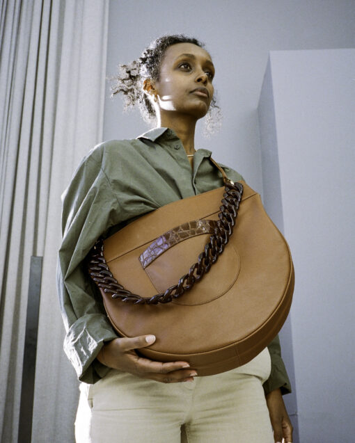 large besace bag revisited. Elegant, original style. tortoiseshell chain. unique design. half-moon that can be worn on the shoulder or across the chest. practical, decorative front pocket. holds a notebook and A4 laptop.